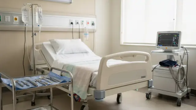 Geburt einleiten: Klinikzimmer mit Überwachungsgerät, Infusionsständer und vorbereitetem Bett