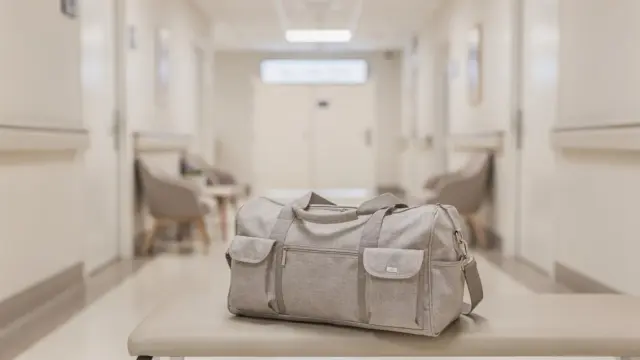 Geburtstasche und Krankenhausflur zum Thema Wehen und Fahrt ins Geburtshaus oder Krankenhaus