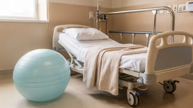 Geburtspositionen bei Wehen: Birthing-Ball, Bett und Geburtsraum in einer klinischen Umgebung